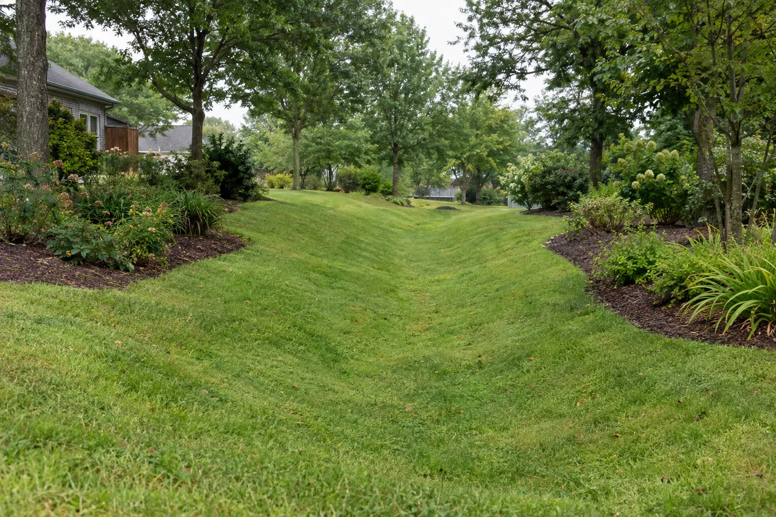 Broad grass swale curving between garden beds.